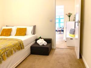 - une chambre avec un lit et un réfrigérateur dans l'établissement Eastbourne Beach Pier Apartment, à Eastbourne