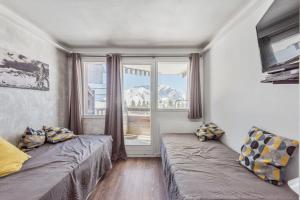 ein kleines Zimmer mit 2 Betten und einem Fenster in der Unterkunft Residences Quartier Falaise - maeva Home in Avoriaz