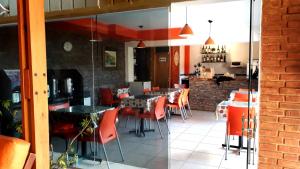 ein Esszimmer mit orangefarbenen Stühlen und Tischen in einem Restaurant in der Unterkunft Hotel Francia in San Rafael