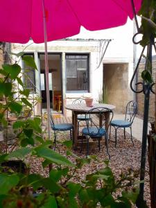 eine Terrasse mit einem Tisch, Stühlen und einem Sonnenschirm in der Unterkunft La cordonnerie in Loches