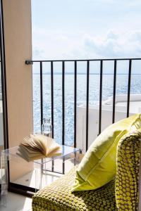 a balcony with a chair and a table and the ocean at I Bastioni San Domenico - Boutique Hotel in Gallipoli
