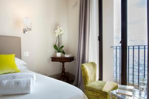 a bedroom with a bed and a chair and a window at I Bastioni San Domenico - Boutique Hotel in Gallipoli