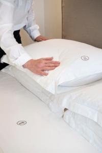 a chef is putting a pillow on a bed at I Bastioni San Domenico - Boutique Hotel in Gallipoli