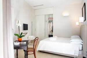 a bedroom with a bed and a desk with a table at I Bastioni San Domenico - Boutique Hotel in Gallipoli