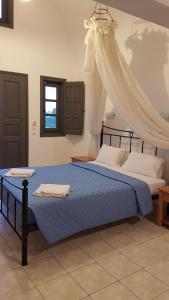 1 dormitorio con 1 cama azul con dosel en Dagris Villa Studios, en Kamari