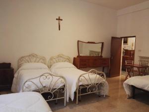 um quarto com duas camas e uma cruz na parede em Villa Sacro Cuore em San Giovanni Rotondo