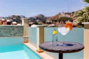 a drink on a table with an orange and a bottle at Cotobro Rental House in Almuñécar
