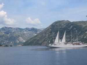 a cruise ship on the water with mountains in the background at Apartmani Jasmina in Kotor
