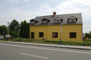 ein gelbes Haus am Straßenrand in der Unterkunft Hotel Pudlov in Bohumín