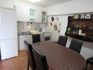 a kitchen with a table and chairs and a kitchen with a white refrigerator at Apartmani Jasmina in Kotor