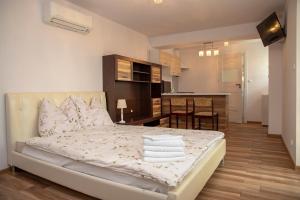 a bedroom with a bed with pillows and a kitchen at Pokoje Gościnne Angelika in Swarzewo
