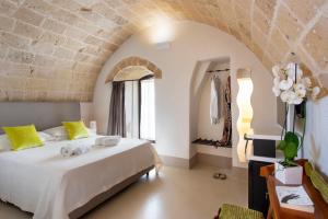a bedroom with a large white bed with yellow pillows at I Bastioni San Domenico - Boutique Hotel in Gallipoli