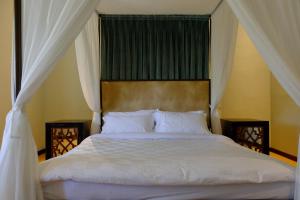 ein Schlafzimmer mit einem weißen Bett mit Himmelbett in der Unterkunft Mom's Corner in Malang + 7 Fotos