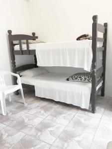 1 dormitorio con litera y silla en Pousada Villa Di Loire, en Balneário Camboriú