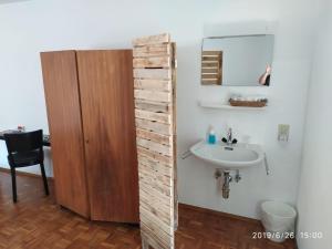 baño con pared de madera junto a un lavabo en Il torchio antico en Arzo