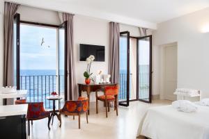 a bedroom with a bed and a table and chairs at I Bastioni San Domenico - Boutique Hotel in Gallipoli