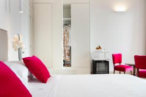 a bedroom with a white bed with red pillows at I Bastioni San Domenico - Boutique Hotel in Gallipoli
