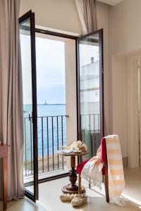 a room with a balcony with a view of the ocean at I Bastioni San Domenico - Boutique Hotel in Gallipoli