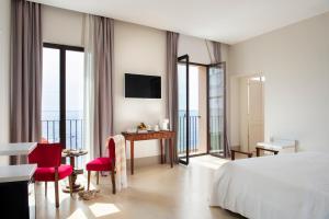 a hotel room with a bed and a desk and chairs at I Bastioni San Domenico - Boutique Hotel in Gallipoli