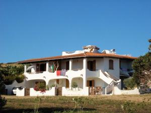 a large white house with a red roof at Valledoria holiday flats in Valledoria