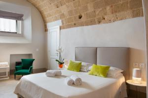 a bedroom with a large white bed with yellow pillows at I Bastioni San Domenico - Boutique Hotel in Gallipoli
