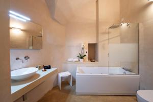 a bathroom with a tub and a sink and a toilet at I Bastioni San Domenico - Boutique Hotel in Gallipoli