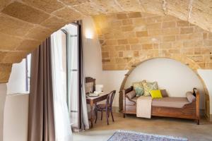 a living room with a bed and a table at I Bastioni San Domenico - Boutique Hotel in Gallipoli