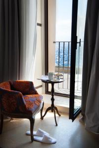 a living room with a chair and a table and a window at I Bastioni San Domenico - Boutique Hotel in Gallipoli