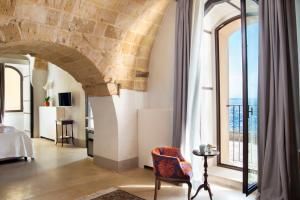 a room with a bed and a large window at I Bastioni San Domenico - Boutique Hotel in Gallipoli
