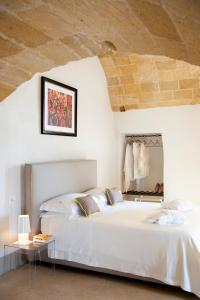 a bedroom with a large white bed and a mirror at I Bastioni San Domenico - Boutique Hotel in Gallipoli