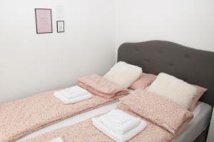 ein Bett mit rosa und weißen Decken und Kissen in der Unterkunft Bistrik Rose Apartment in Sarajevo