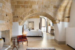 una camera con letto e parete in pietra di I Bastioni San Domenico - Boutique Hotel a Gallipoli