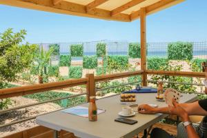 a woman sitting at a table on a balcony at LOCA BEACH in Taghazout