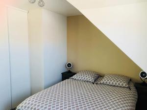 a bedroom with a bed with two pillows on it at Maison de ville à Albert in Albert