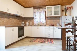 una cocina con armarios blancos y una ventana en To Archontiko tis Nikis, en Ioannina