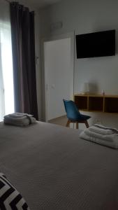 1 dormitorio con 1 cama y 1 silla azul en Dolce Vita en Zafferana Etnea