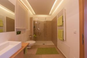 a bathroom with a white sink and a toilet at Appartements Verdinserhöhe in Schenna