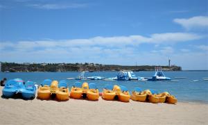 a row of inflatables on a beach with the water at Hotel Santa Catarina Algarve in Portimão
