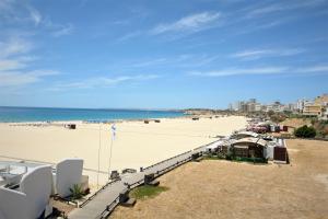 a view of a beach with chairs and the ocean at Hotel Santa Catarina Algarve in Portimão