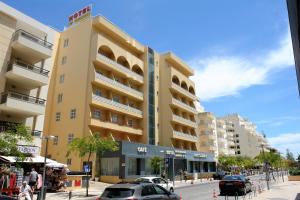 een gebouw in een straat waar auto's voor geparkeerd staan bij Hotel Santa Catarina Algarve in Portimão