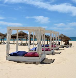 a row of beds on a sandy beach at Hotel Santa Catarina Algarve in Portimão