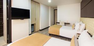 Habitación de hotel con 2 camas y TV de pantalla plana. en Hotel American Visa Tower, en Bogotá