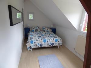 1 dormitorio con cama con edredón y ventana en Gîte Le Petit Chalet avec parking gratuit, en Étretat