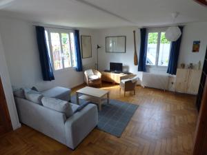 een woonkamer met een bank en een tafel bij Gîte Le Petit Chalet avec parking gratuit in Étretat