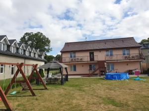 a yard with a playground and a house at POKOJE U MIKOŁAJA in Kamień Pomorski