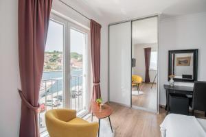 a hotel room with a bed and a desk and a balcony at Stone House Buljanovic in Sali