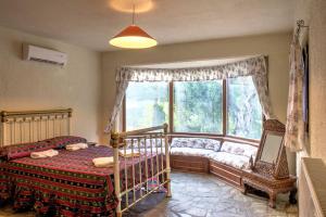 ein Schlafzimmer mit einem Kinderbett und einem großen Fenster in der Unterkunft Villa Brigadoon Corfu in Agios Ioannis Peristerion