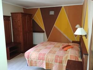 a bedroom with a bed with a geometric headboard at CHALET SEGGIOVIA in Pontechianale