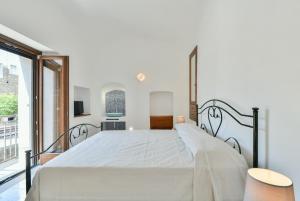 a bedroom with a large white bed and a window at Casa Vacanze Don Mimì in Acciaroli