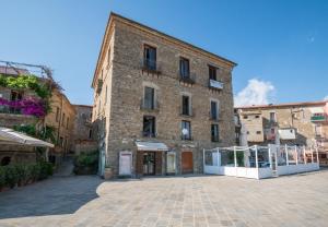 a large brick building with a courtyard in front of it at Casa Vacanze Don Mimì in Acciaroli